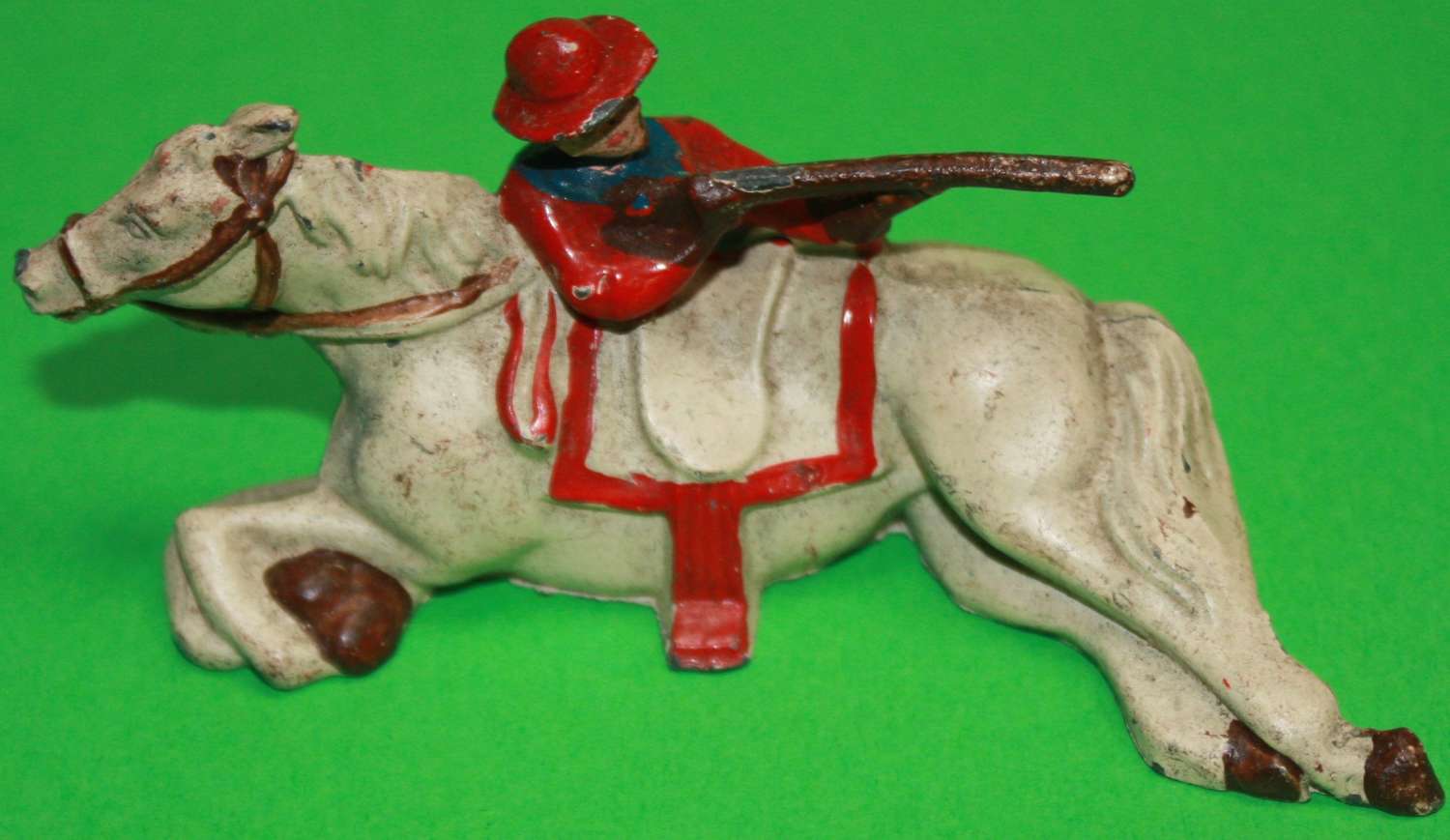 A SCARCE GOOD EXAMPLE OF THE JOHN HILL & CO COWBOY FIRING OVER HORSE